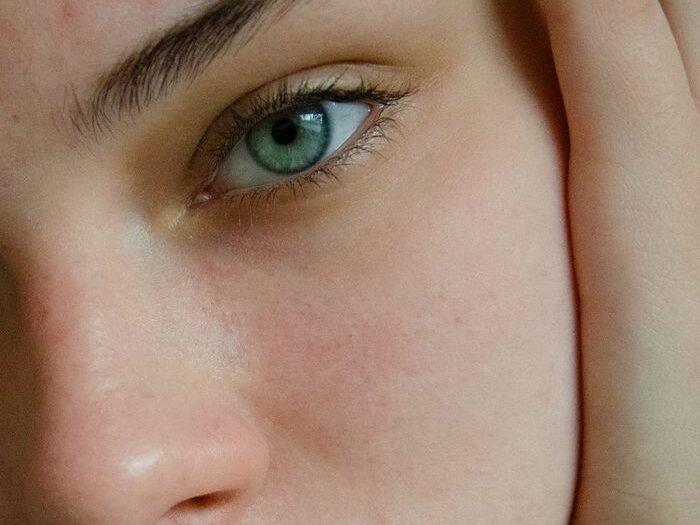 Close-up portrait showcasing natural skin texture and eye detail, emphasizing beauty and authenticity.
